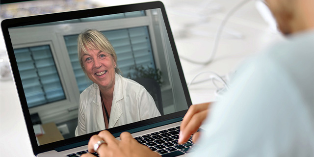 A person participating in a digital video consultation with a dermatologist through Askin.